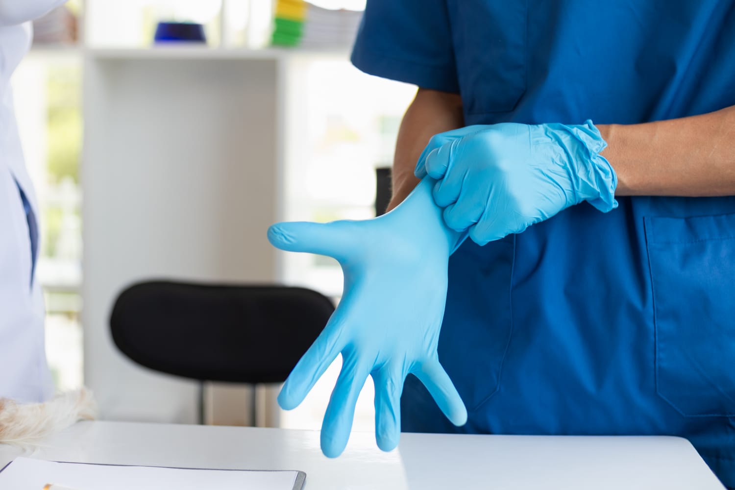 Hände in blauen Einmalhandschuhen
