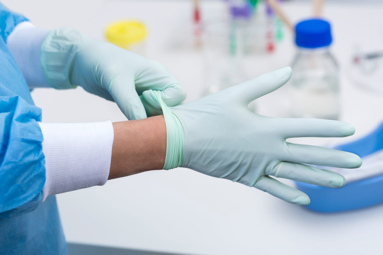 Hände ziehen Einmalhandschuhe an